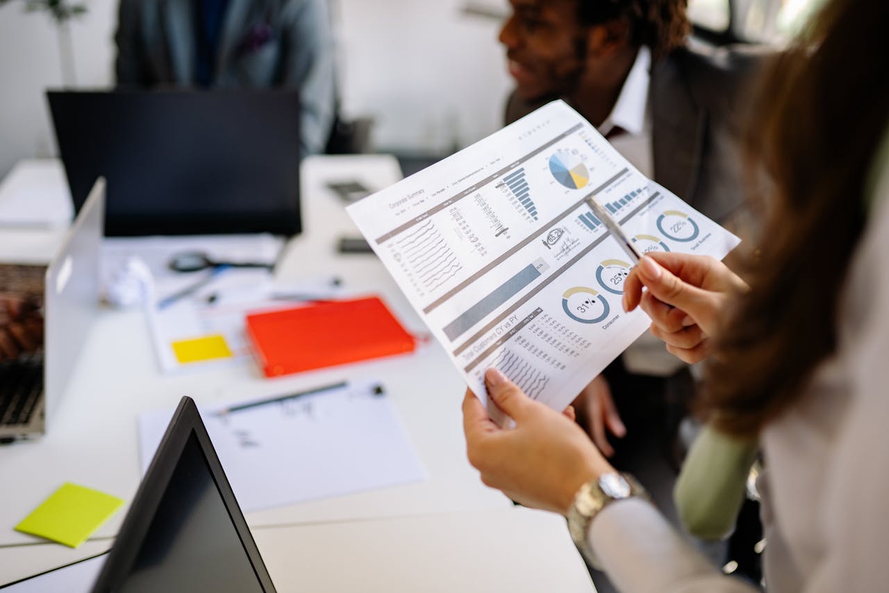 Professionals reviewing business charts and documents in a team meeting.