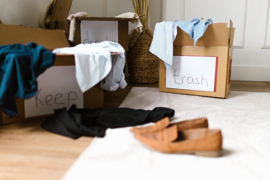 Decluttering concept using labeled boxes for sorting clothes in a home setting.